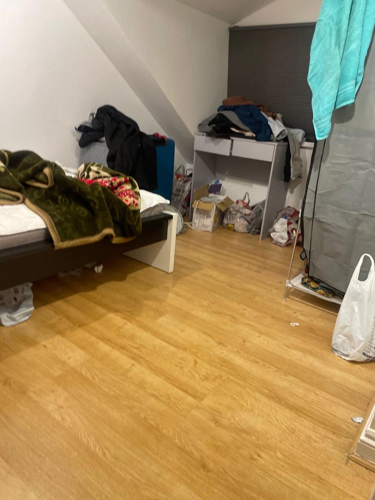 Bright bedroom with warm wood-style flooring, a...
