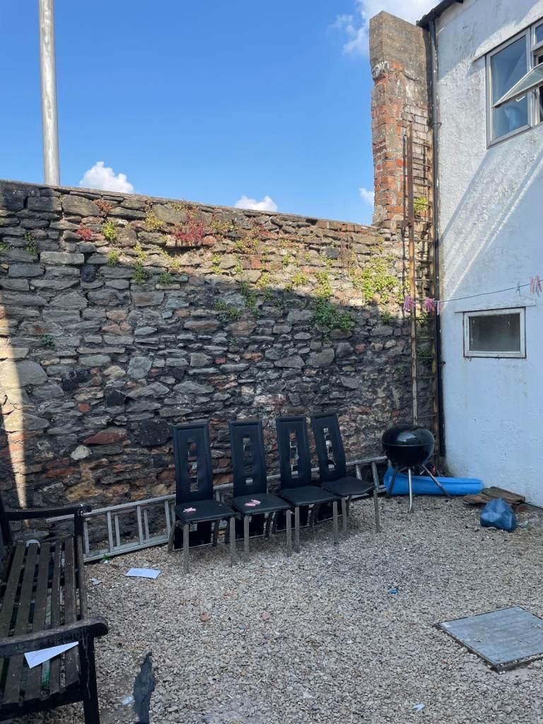 Quiet private courtyard with stone wall and pat...