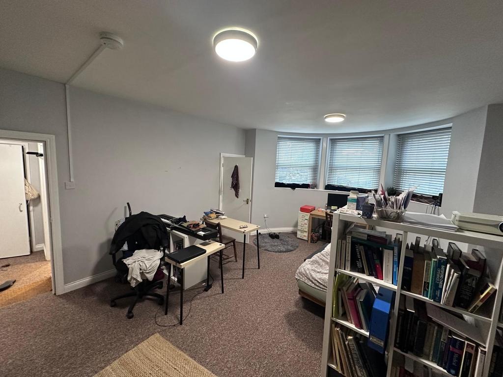 Spacious double bedroom with a curved bay windo...