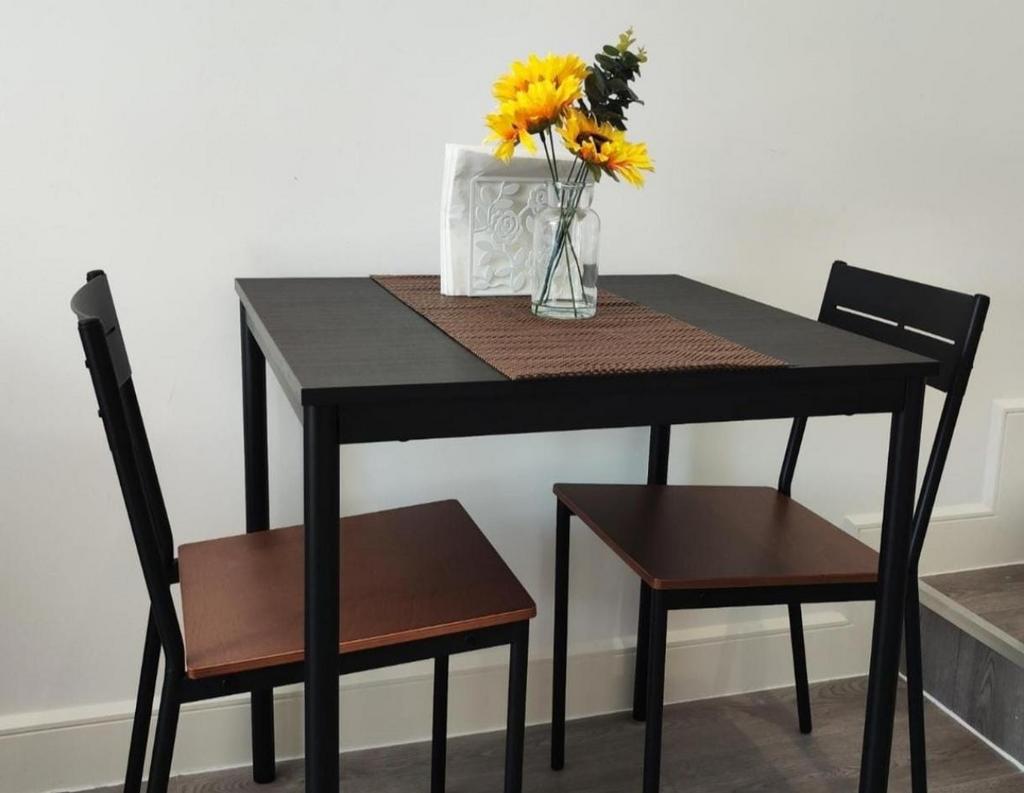 Compact dining set with sunflowers on table...