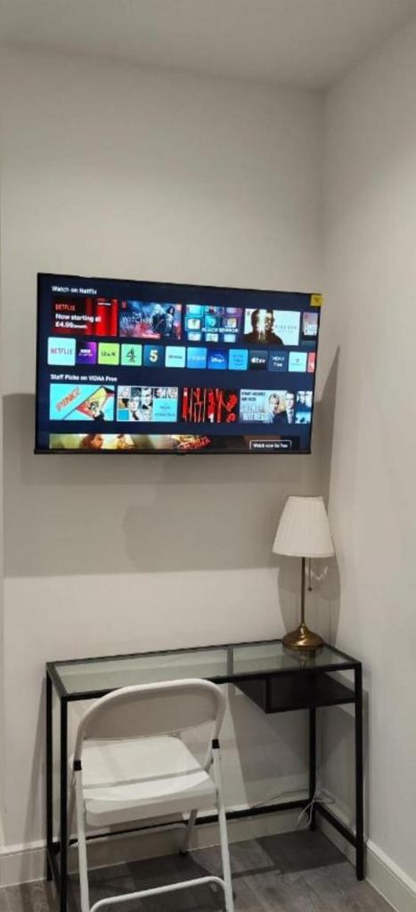 Compact study nook with wall TV and desk lamp...