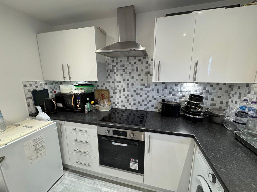Modern fitted kitchen with tiled splashback...