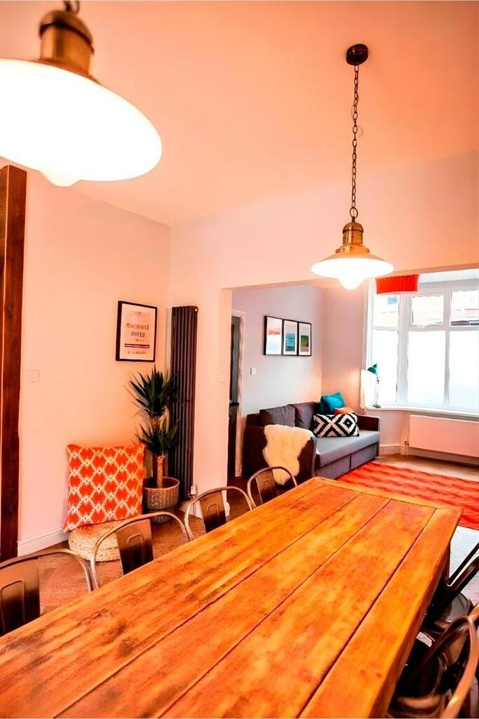 Bright communal lounge with long wooden table...