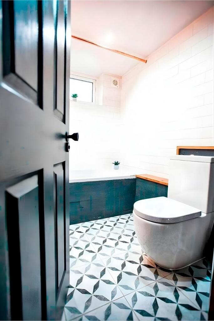 Bright tiled bathroom with patterned floor...