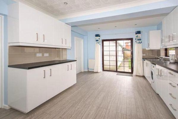 Bright modern kitchen with extensive white cabi...