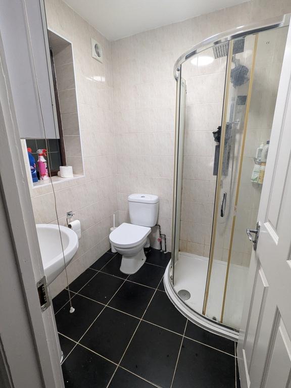 Neat, modern bathroom with a curved glass showe...