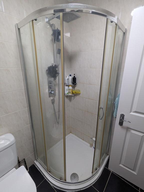 Bright, modern bathroom featuring a curved glas...