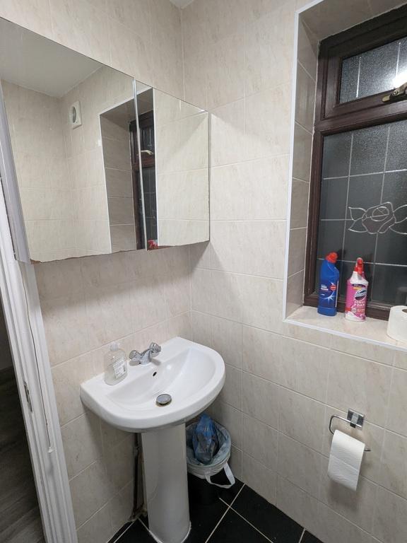 Bright, tidy bathroom with a pedestal sink, mir...