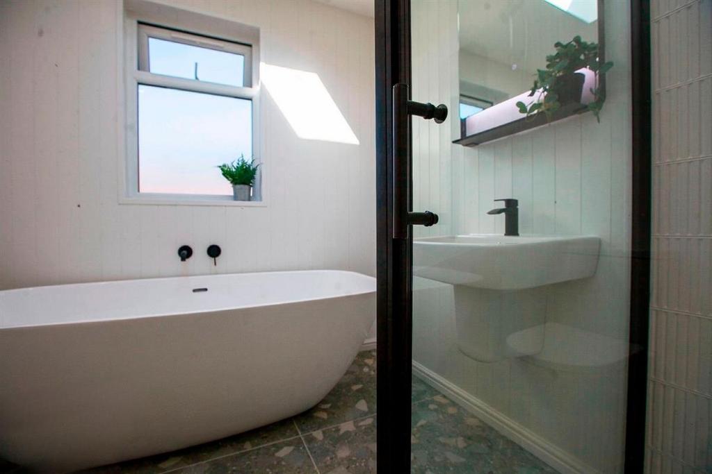 Modern bathroom with freestanding bath and slee...
