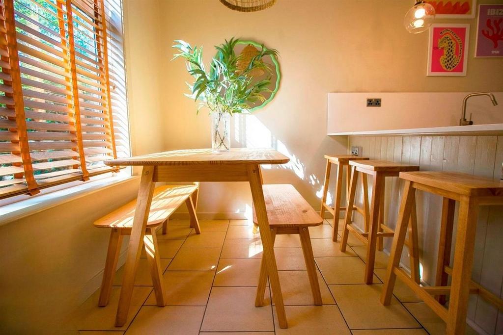 Bright kitchen with wooden seating and sunny ba...