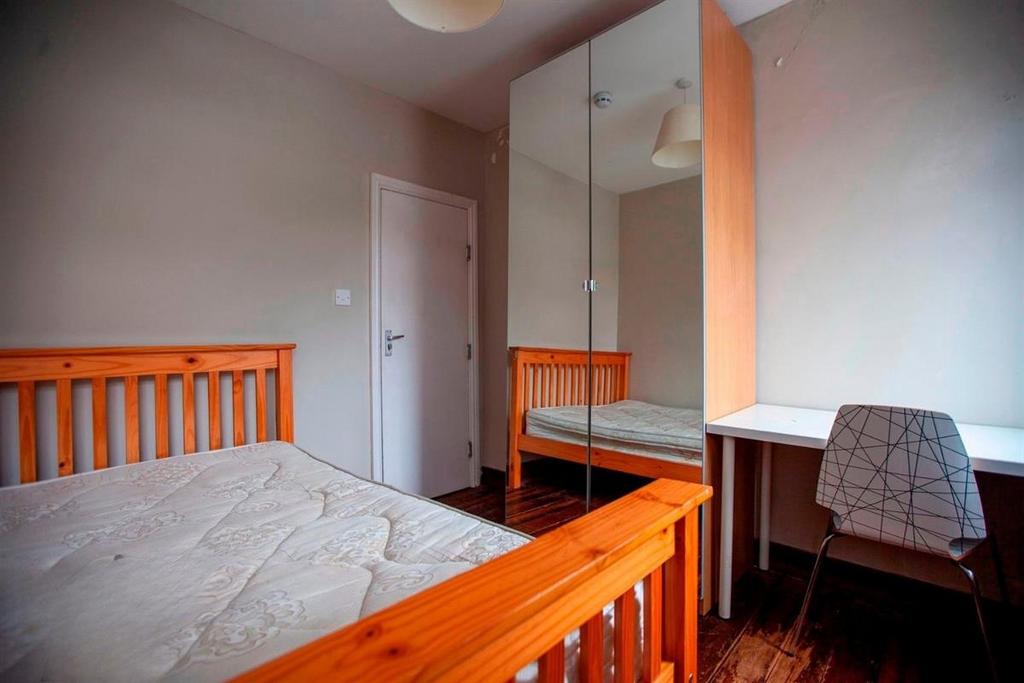Bright furnished bedroom with desk and wardrobe...
