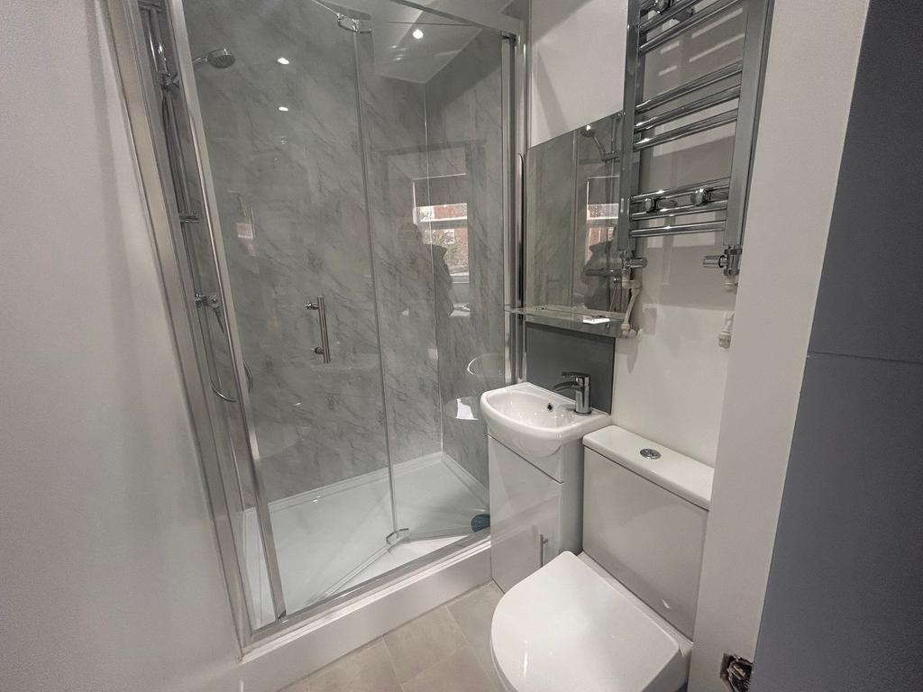 Modern bathroom with glass shower and heated ra...