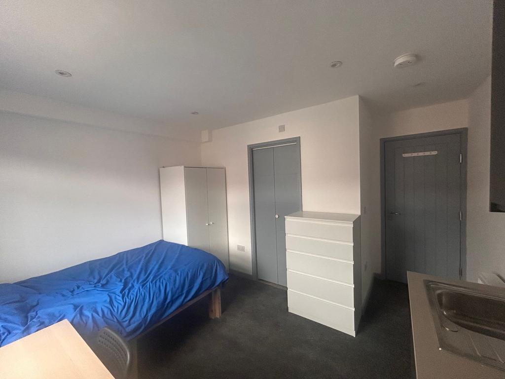 Compact furnished room with wardrobe and chest...