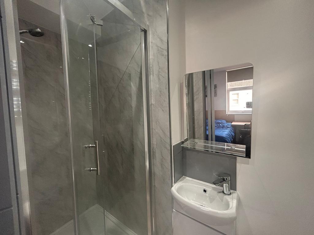 Modern ensuite with glass shower and basin...
