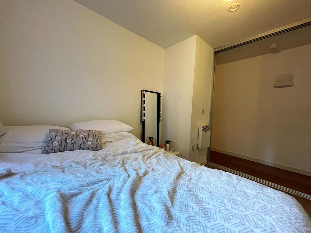 Bright, simply styled bedroom with a comfortabl...
