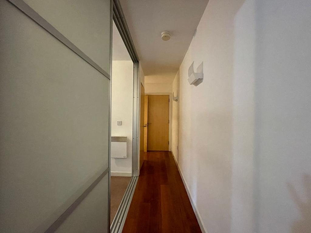 Bright, modern hallway with wood flooring, whit...