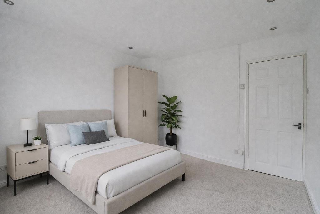 Minimalist bedroom with plants and neutral tones.p