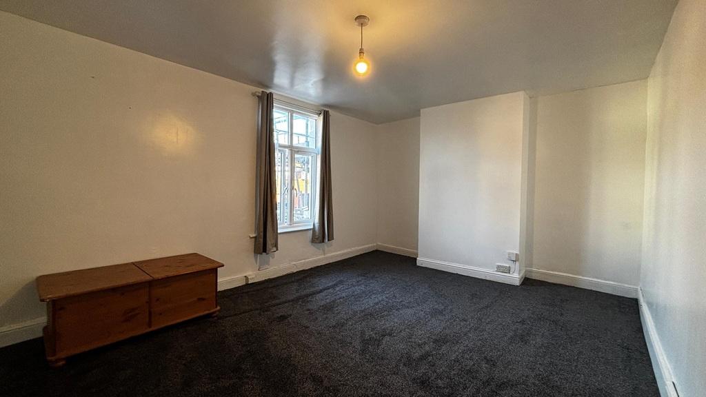 Spacious bedroom with large window and neutral ...