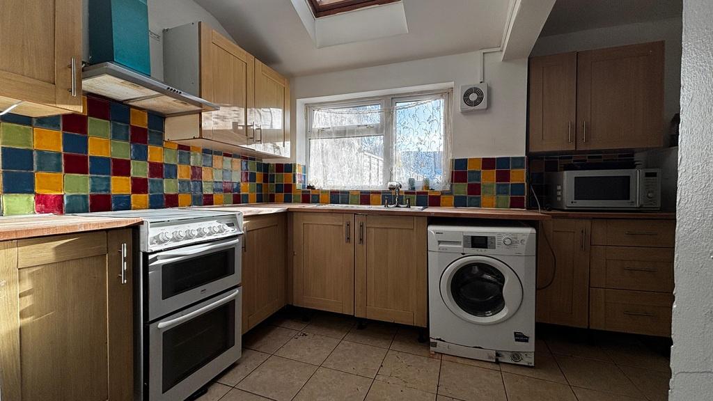 Bright kitchen with colorful tiled splashback...