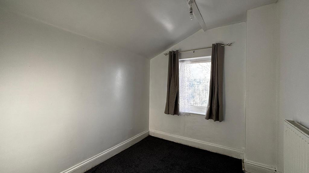Compact bedroom with window and neutral decor...