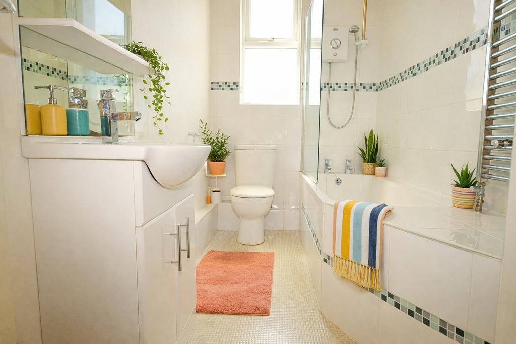 Bright, modern bathroom with a bath and shower,...