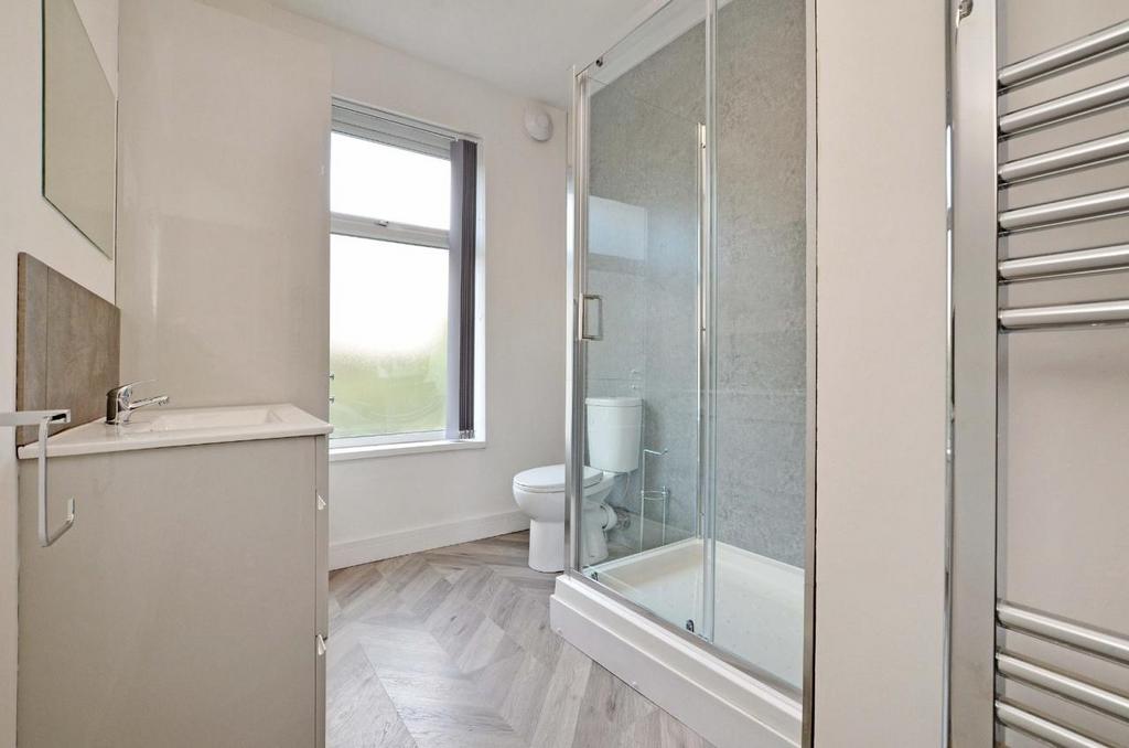 Bright, modern bathroom with a glass-enclosed s...