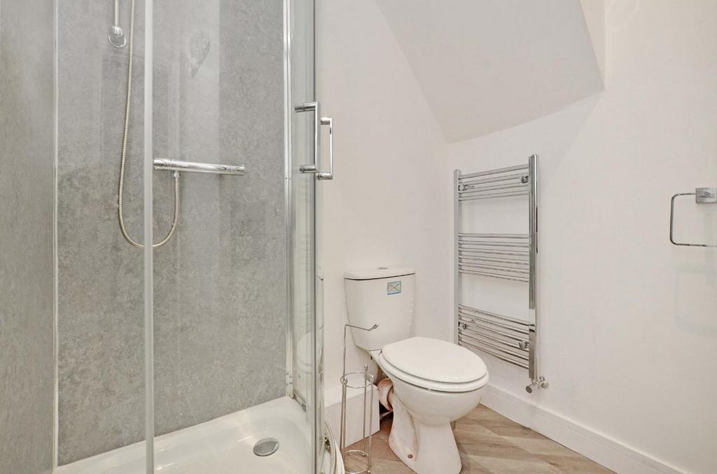 Bright, modern bathroom with a glass shower enc...