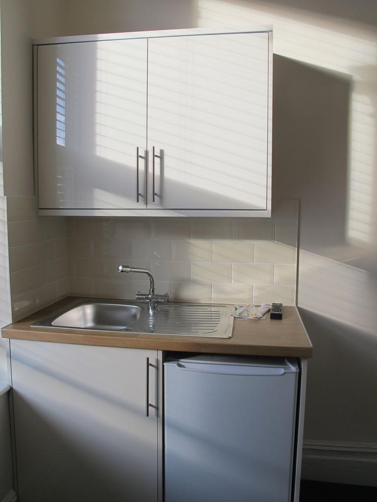 Compact modern kitchenette with a stainless-ste...