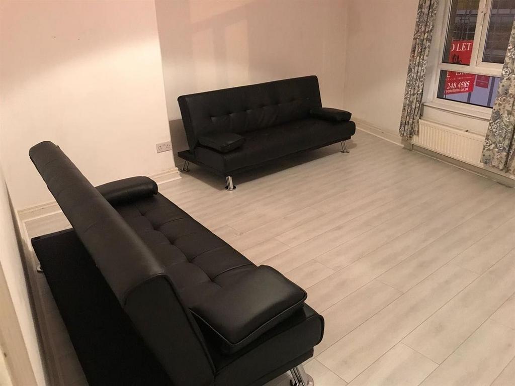 Modern lounge with two black sofas and bright w...