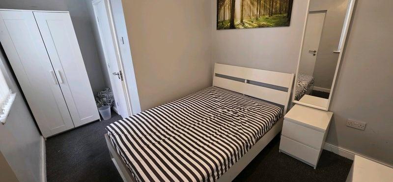 Bright tidy bedroom with bed and wardrobe...