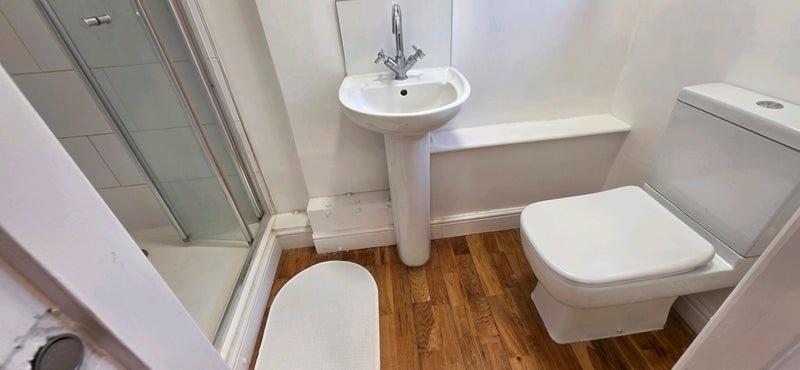 Clean modern bathroom with shower and wood-styl...