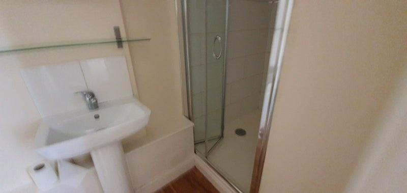 Compact bathroom with a walk-in shower...
