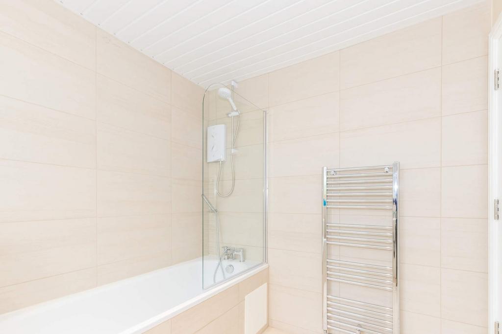Bright modern bathroom with bath and heated rai...