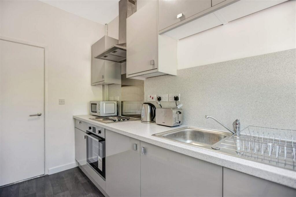 Modern galley kitchen with integrated appliance...