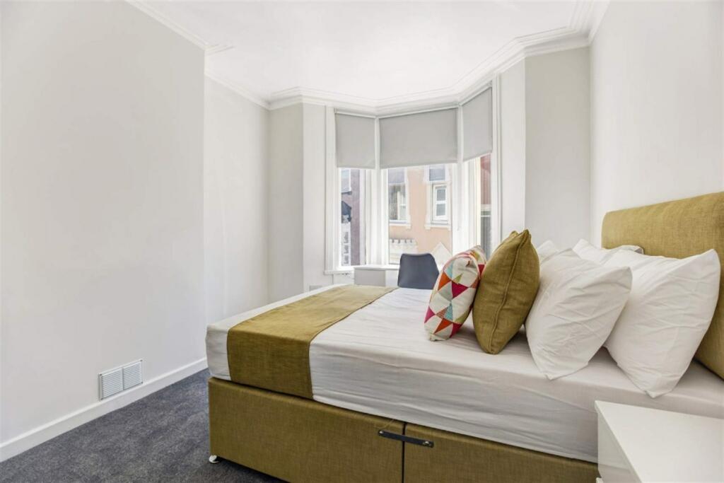 Bright bedroom with bay window and storage bed...