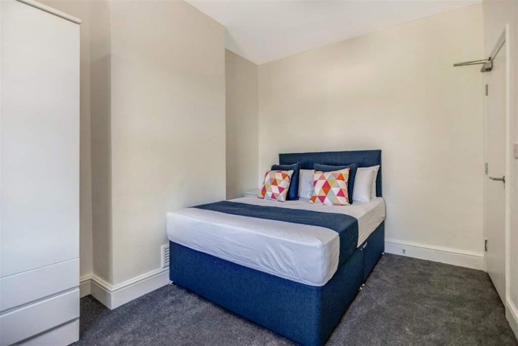 Bright, tidy bedroom with upholstered double be...