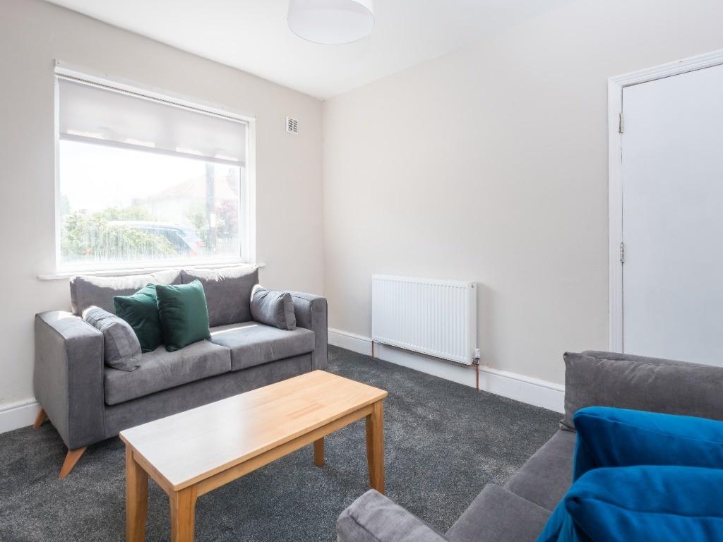 Bright, neutral living room with sofa and windo...