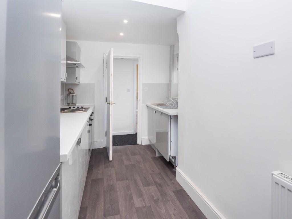 Clean modern galley kitchen with white units...