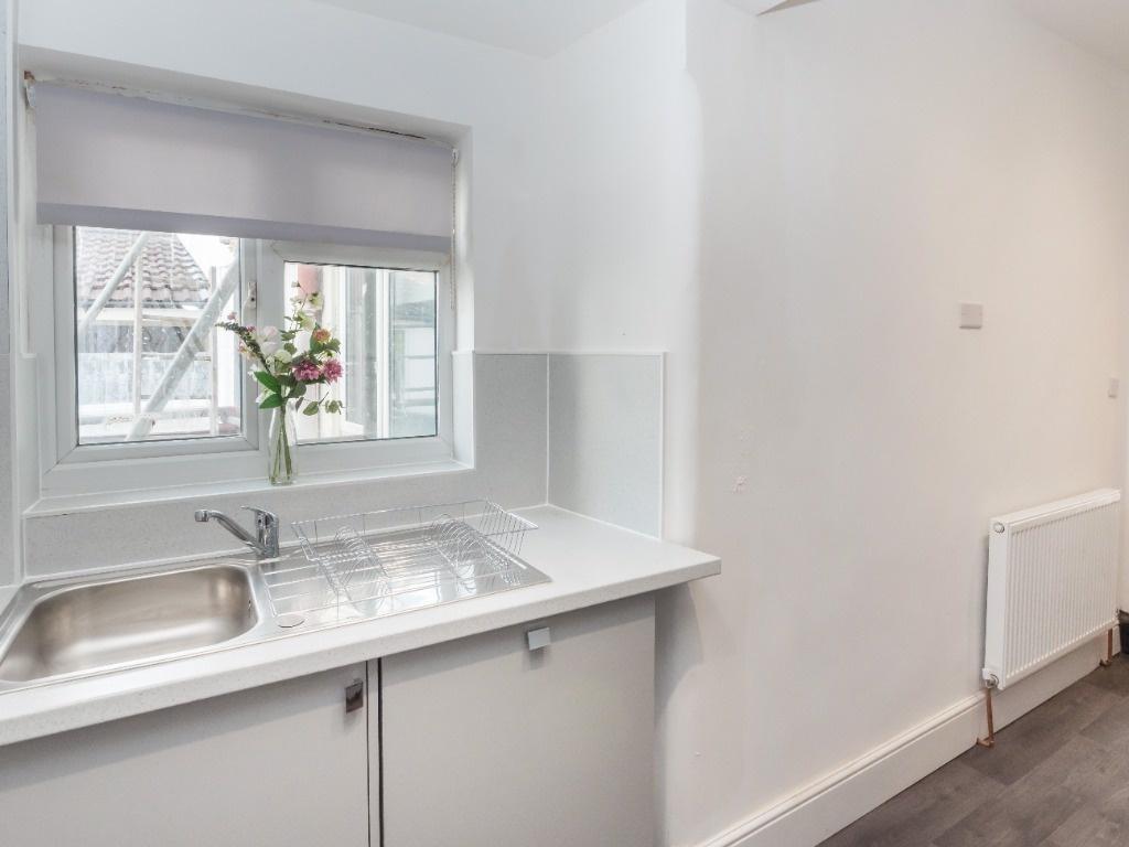 Bright kitchenette with sink and window view...