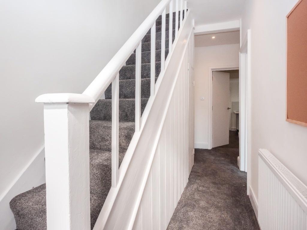 Bright modern hallway with carpeted staircase...