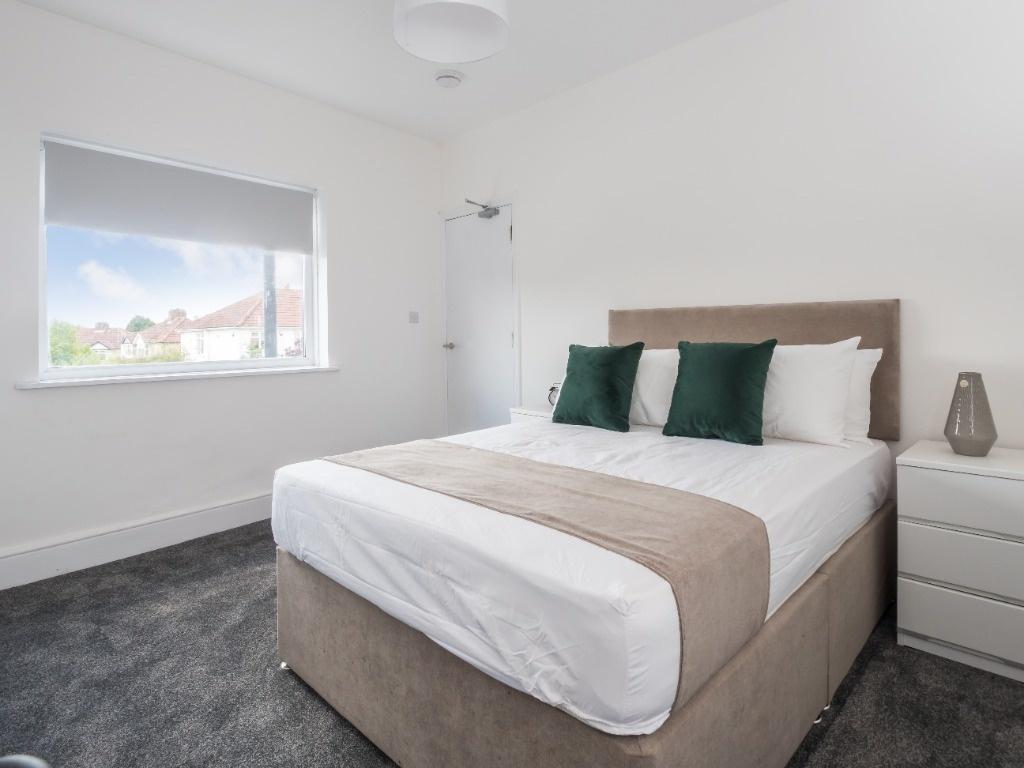 Bright, modern bedroom with double bed and stor...