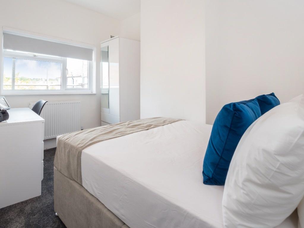 Bright, neatly furnished bedroom with study are...