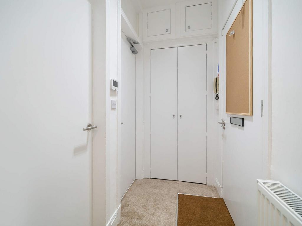 Bright, clean hallway with storage cupboards...