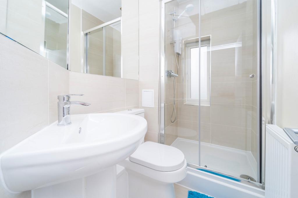 Bright modern bathroom with shower and clean wh...