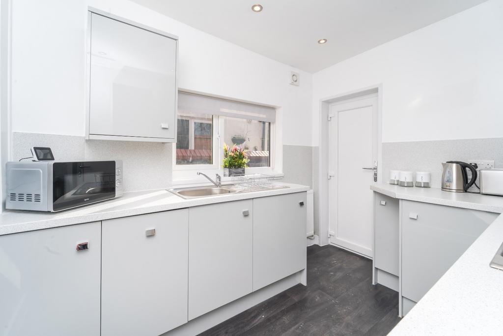Bright modern kitchen with clean white units...