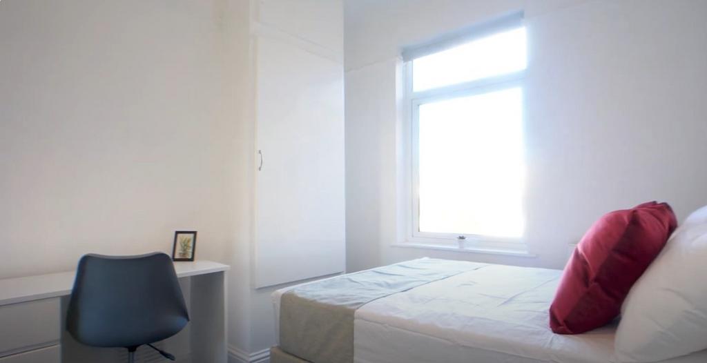 Bright simple bedroom with desk and comfy bed...