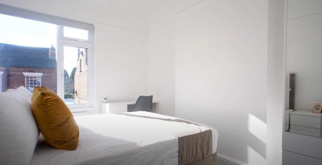 Bright, simple bedroom with large window...