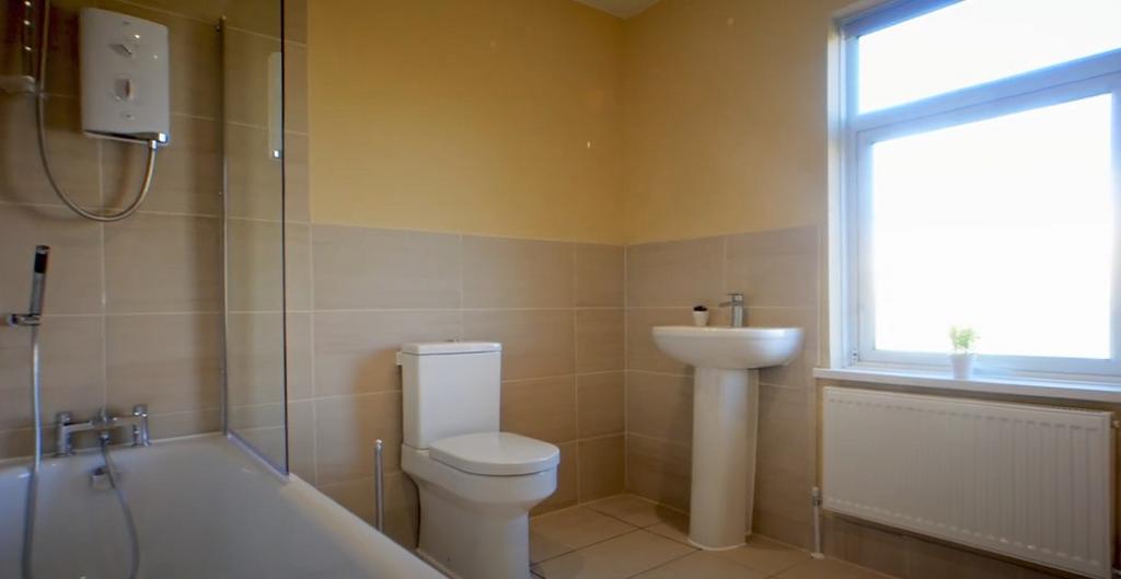 Bright, tidy bathroom with bathtub and window...