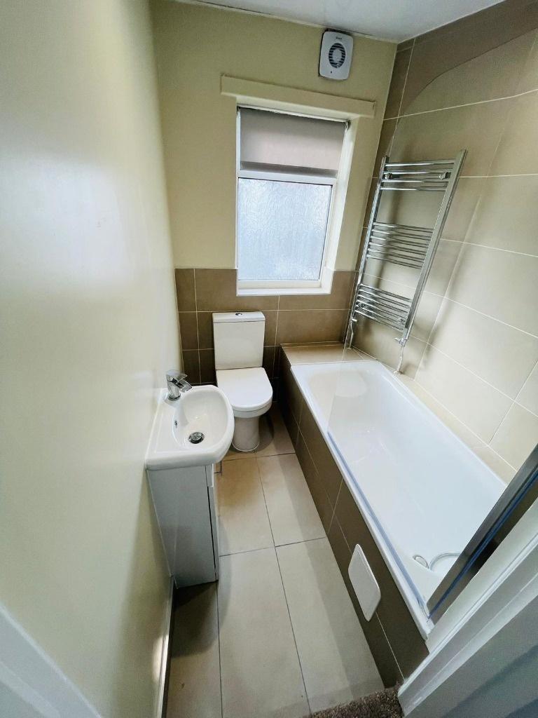 Bright modern bathroom with bath and towel rail...