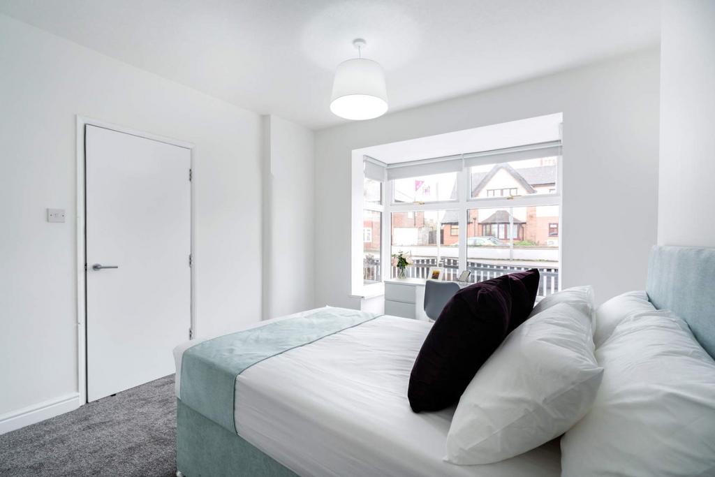 Bright bedroom with large bay window and modern...